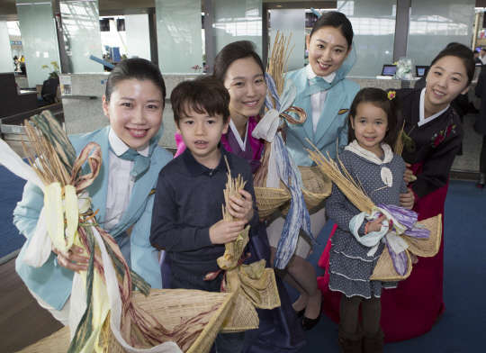 인천공항 탑승수속 카운터에서 대한항공 객실승무원들과 인천여객서비스지점 직원들이 어린이 승객들과 함께 복조리 행사 기념촬영을 하고 있다.  <대한항공 제공>